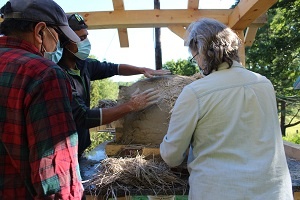 Instructor and students crafting an outdoor earthen bake oven